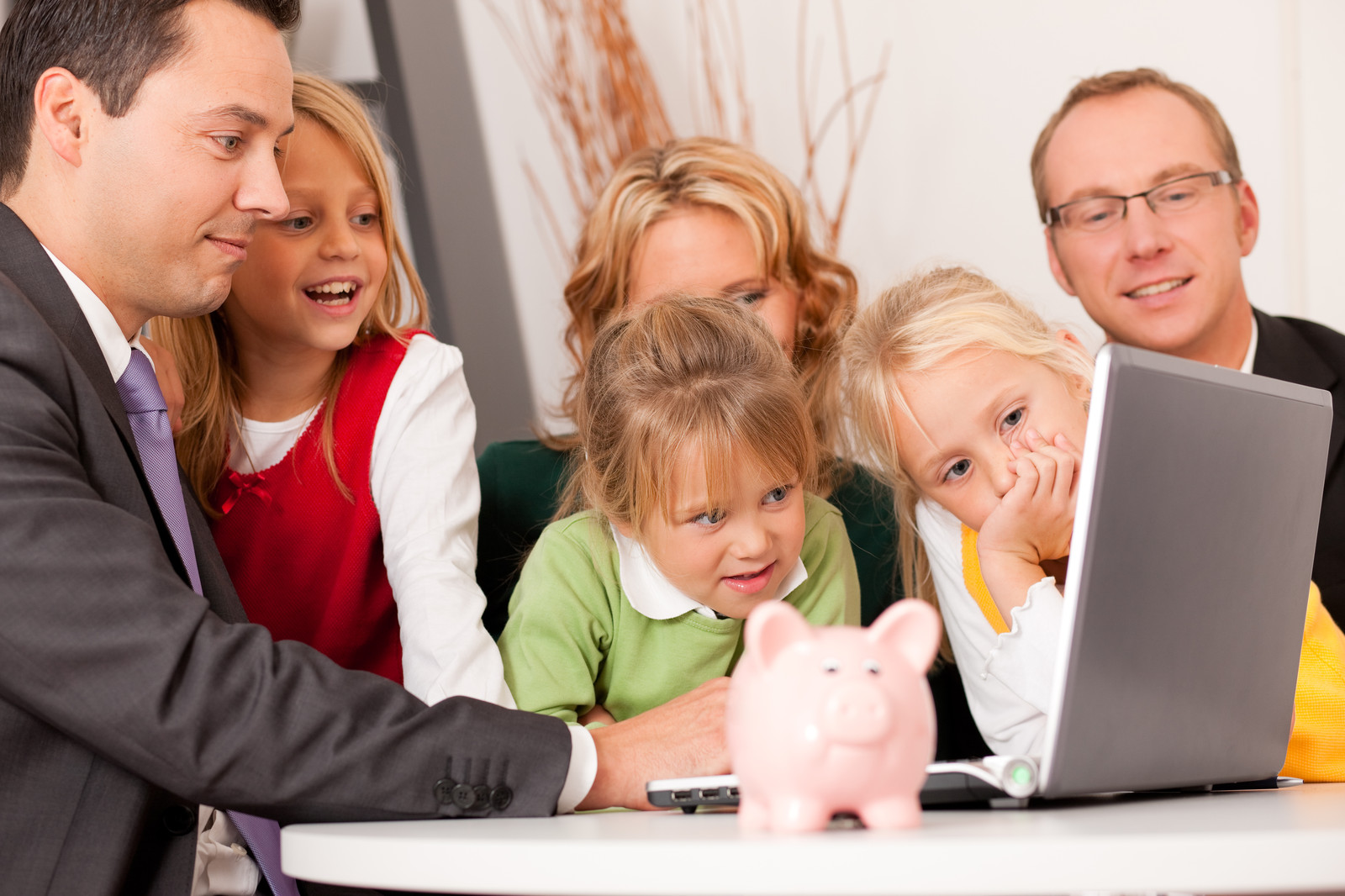 Family around a computer with a piggy bank